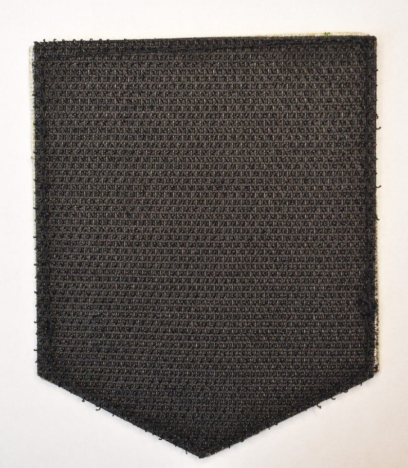 May include: A black hook and loop fastener patch with a textured surface.