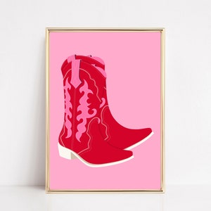May include: A pair of red cowboy boots with pink embroidery on a pink background.
