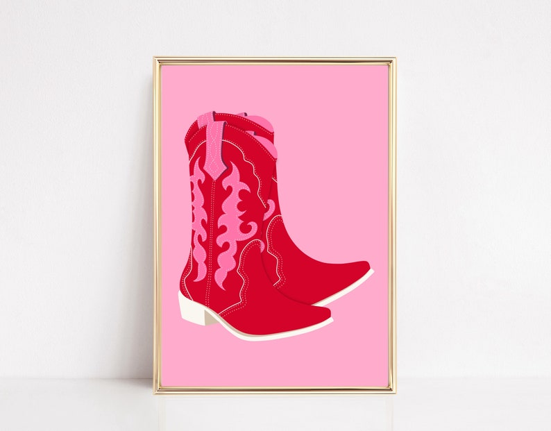 May include: A pair of red cowboy boots with pink embroidery on a pink background.