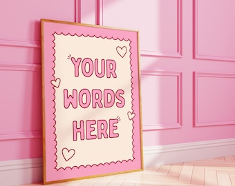 May include: A framed pink and gold print with the words "YOUR WORDS HERE" in a bubble font. The print has a scalloped border and heart accents. The background is a light cream color.