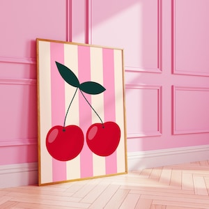 May include: A framed print with a pink and cream striped background featuring two red cherries with green stems and leaves.