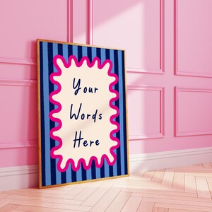 May include: A framed art print with a gold border. The artwork features a blue and navy striped background with a cream-coloured, wavy-edged shape in the centre. The words "Your Words Here" are written in black script.