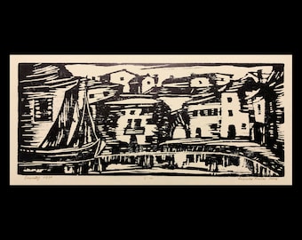 May include: A black and white woodcut print depicting a village with houses and a sailboat in the foreground. The print is titled "Seestück 1918" and signed "V.K.S." in the lower right corner.