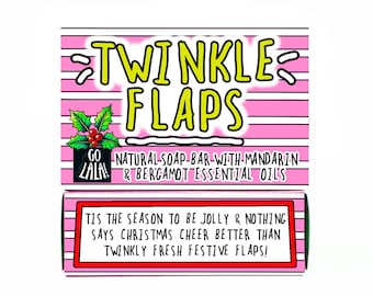 May include: A pink and white striped box with the words "TWINKLE FLAPS" in yellow and black. The box also has text that reads "NATURAL SOAP BAR WITH MANDARIN & BERGAMOT ESSENTIAL OILS" and "TIS THE SEASON TO BE JOLLY & NOTHING SAYS CHRISTMAS CHEER BETTER THAN TWINKLY FRESH FESTIVE FLAPS!"