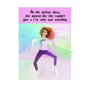 May include: A doll with red hair is dancing in a kitchen. The doll is wearing a white shirt with the word "LOVE" on it and purple trousers. The background is a blurred image of a kitchen with a pink, blue, and green gradient.