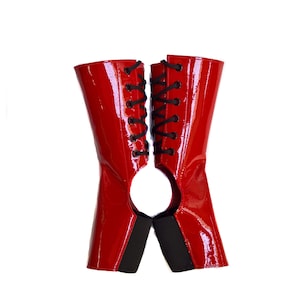 May include: A pair of red patent leather boots with black laces. The boots are open at the back and have a high heel.