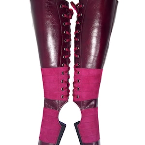 May include: A pair of burgundy leather boots with a lace-up front and a suede panel on the shaft.