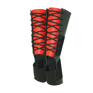 May include: A pair of black leather boots with red laces. The boots have a tall shaft and a pointed toe.