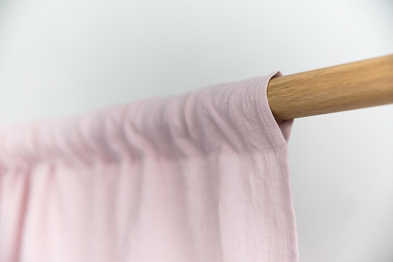 Puede incluir: Una cortina de lino rosa p&aacute;lido colgando de una barra de madera.