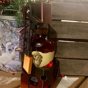 Może przedstawiać: Drewniany brązowy uchwyt na butelkę z butelką whisky w środku. Butelka ma etykietę z obrazkiem bawoła i tekstem "WENTUUCKY STRAIGHT BOURBON WHISKEY".