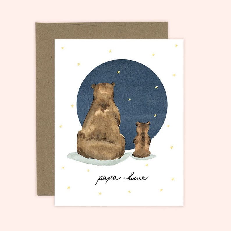 May include: A watercolor illustration of two brown bears sitting back to back in front of a blue moon with stars. The text "papa bear" is written below the bears.