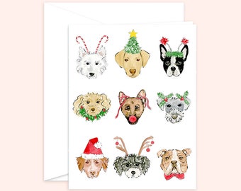 Puede incluir: Una tarjeta de felicitación blanca con ilustraciones en acuarela de nueve razas de perros, cada una adornada con accesorios festivos navideños como gorros de Papá Noel, cuernos de bastón de caramelo y sombreros de árbol de Navidad. Se incluye un sobre blanco.