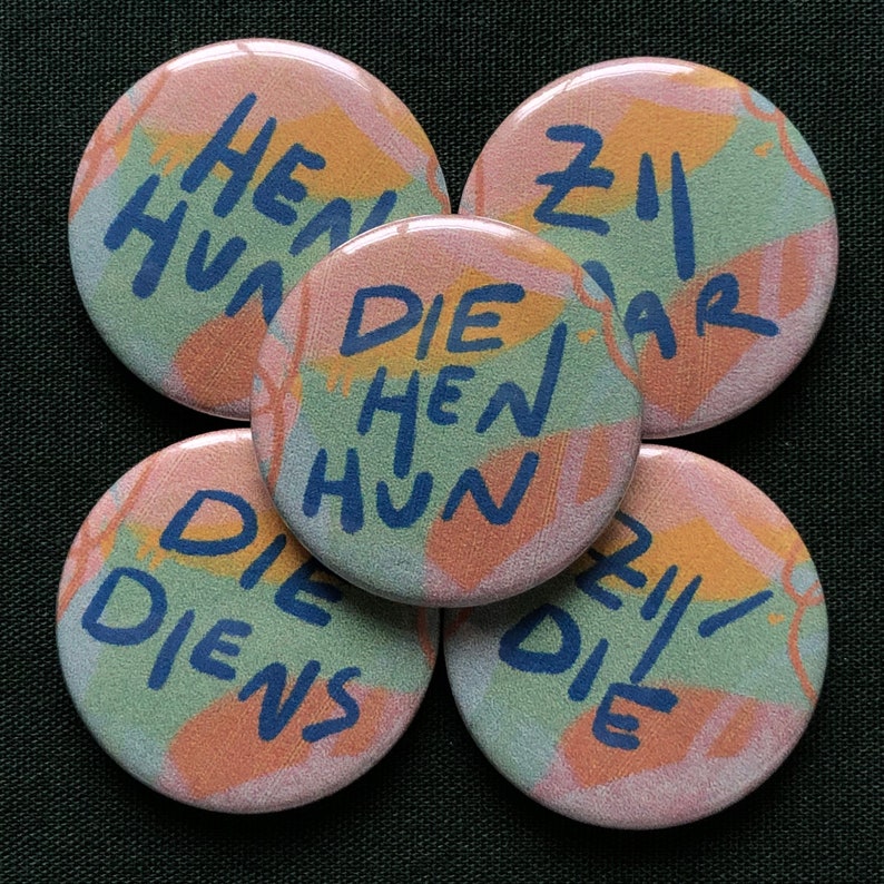 Puede incluir: Cinco botones redondos con dise&ntilde;os abstractos en tonos pastel rosa, verde y naranja. Cada bot&oacute;n tiene texto azul. El texto en los botones incluye las palabras "HEN HUN", "ZII WAR", "DIE HENS HUN" y "DIE DIENS".