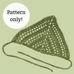 May include: A handmade, olive green crochet bandana with a triangular shape and open weave design. The bandana has long, thin ties for securing around the neck or head. The text "Pattern only!" is in a white circle in the upper left corner.