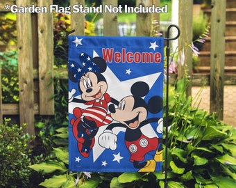 May include: A blue and red garden flag with Mickey and Minnie Mouse in a patriotic design. The flag says "Welcome" and has white stars on a blue background.