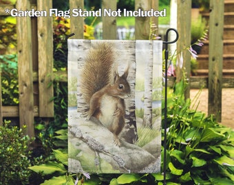 May include: A garden flag with a watercolor illustration of a squirrel sitting on a branch in a birch forest. The flag is white with brown, green, and gray accents.