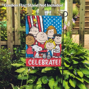 Peut inclure: Un drapeau de jardin représentant les personnages de Peanuts célébrant avec un fond de drapeau américain. Le drapeau porte l'inscription "Celebrate!" et représente Snoopy, Charlie Brown, Lucy, Linus et Sally.