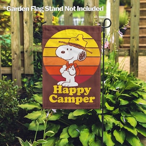 May include: A brown garden flag with a retro sunset design featuring Snoopy dressed as a happy camper. The flag reads "Happy Camper" in yellow letters.