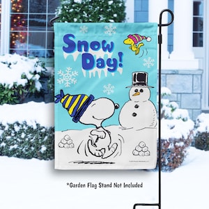 May include: A blue and white garden flag with a snowman, a cartoon dog, and the text "Snow Day!"