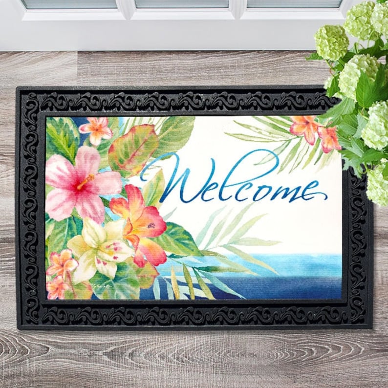 May include: A welcome mat with a tropical floral design and the word "Welcome" in blue script. The mat has a black border with a decorative pattern.