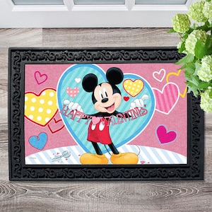 May include: A pink and blue doormat with Mickey Mouse holding a banner that says "Happy Valentines". The background is filled with hearts of different colors and patterns.
