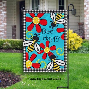 May include: A garden flag with a blue background and a black and white checkered border. The flag features red flowers, yellow and black bees, and the text "Bee Happy".