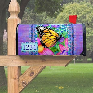 May include: A purple and blue mailbox with a butterfly and flower design. The mailbox has a white number plate with the number 1234 on it.