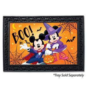 May include: A Halloween-themed doormat featuring Mickey Mouse and Minnie Mouse dressed in costumes. Mickey is a vampire and Minnie is a witch. The doormat has a black frame with a decorative design and the word "BOO!" in large letters.