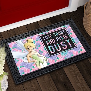 May include: A black doormat with a pink and purple floral design featuring Tinkerbell. The text "Love, Trust and Pixie Dust" is written in white on a black background.
