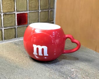 M&M'sの赤または緑の陶器製マグカップ。食器洗い機と電子レンジに対応