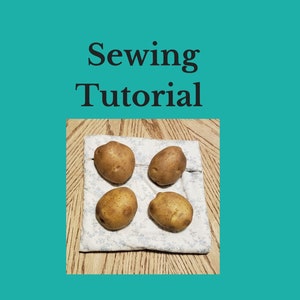 A reusable microwave potato bag in the color of white with light blue floral design with four potatoes resting on them on the dining room table. This product is a sewing tutorial to make potato bags.