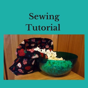 Sewing tutorial to make a reusable popcorn bag. This popcorn bag made of apple theme fabric has just come out the microwave and popped kernels are pouring out of it into a green bowl.