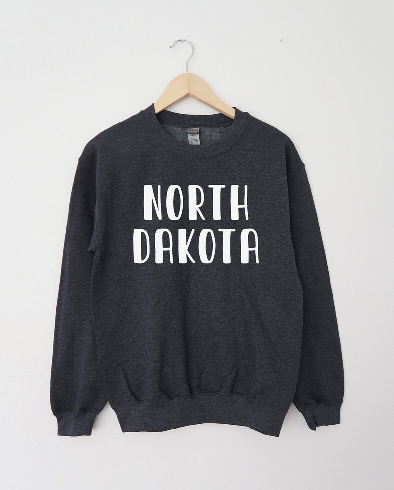 May include: A dark gray sweatshirt with the text "NORTH DAKOTA" printed in white on the front.
