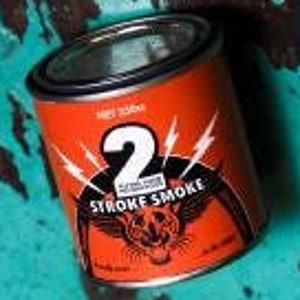 Może przedstawiać: Czerwono-czarna metalowa puszka z nadrukiem cyfry "2" i napisem "2 Stroke Smoke". Na puszce znajduje się grafika przedstawiająca panterę z błyskawicami.