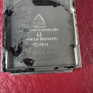 May include: A silver watch back with the text "PLAQUE OR 20 MICRONS FONDO ACER INOXIDABLE 511.0476"