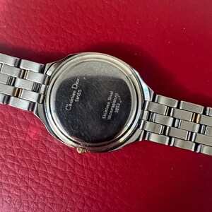 Puede incluir: La parte posterior de un reloj de pulsera de dos tonos, plateado y dorado, con una correa de acero inoxidable. La esfera del reloj tiene el texto "Christian Dior Swiss" y "Stainless Steel Waterresistant 30M/3ATM".