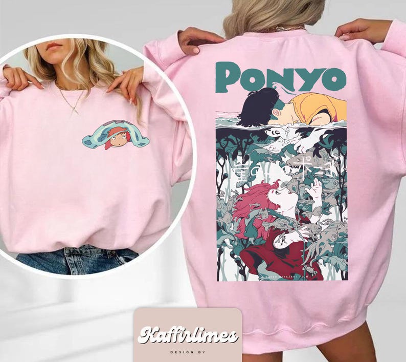 May include: Pale pink sweatshirt with a graphic from the animated film "Ponyo." The front has a small cartoon graphic, while the back displays a larger, colourful illustration with the film's title. The sweatshirt is a soft, casual style.