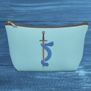 Puede incluir: Una bolsa de cremallera azul claro con una espada envuelta en una cinta azul bordada en la parte delantera.
