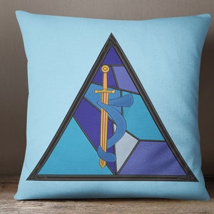 Puede incluir: Una almohada azul con un diseño de vitral de una espada y una serpiente dentro de un triángulo.