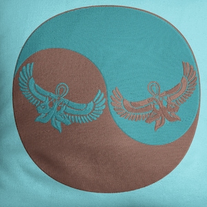 May include: A turquoise blue throw pillow with a brown circle in the center. The circle features two stylized winged figures, one on each side of the circle, facing each other. The figures are brown and have a design that resembles the Egyptian symbol of the Eye of Horus.