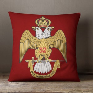May include: Red pillow with a gold embroidered design of two eagles with a crown above them. The eagles are holding a sword and a triangle with the number 32 inside. The text "DEUS MEUMQUE JUS" is written below the eagles.