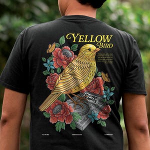May include: Black t-shirt featuring a yellow bird design with the text "YELLOW BIRD". The graphic includes red and blue flowers, butterflies, and a DJ mixer. The shirt also has the text "Pretty Nights".