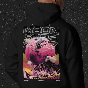 Puede incluir: Sudadera con capucha negra con un estampado gráfico de una luna rosa, montañas y nubes. El texto "THE MOON SLIPS AWAY" está impreso en blanco en la sudadera. El texto "THE DAWN OF THE DAYLIGHT AND WE SEE THE SUN" está impreso en blanco más pequeño debajo de la luna.