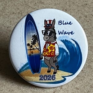 May include: A blue and white button with a cartoon donkey wearing a red vest, sunglasses, and a red, white, and blue hat. The donkey is standing on a beach with a surfboard and a blue wave. The text "Blue Wave 2026" is printed on the button.