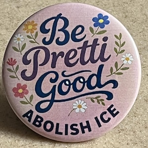 May include: A circular, pink badge featuring the phrase "Be Pretti Good Abolish ICE" in a decorative font. The design includes floral illustrations in shades of blue, yellow, and pink, adding a touch of whimsy.