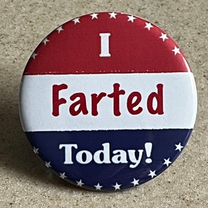 May include: A red, white, and blue button with stars around the edge. The button says "I Farted Today!" in white letters.