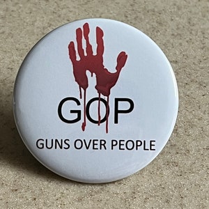 GOP=Guns Over People Pin-Back Buttons or Magnet.