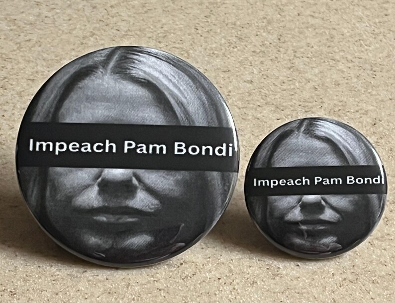 May include: Two round black and white buttons. The buttons feature a grayscale image of a person with a black bar across the eyes. The text "Impeach Pam Bondi" is printed in white on the black bar.