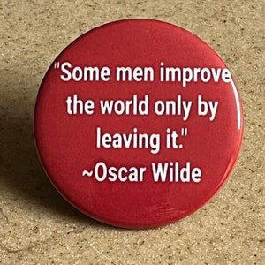 Puede incluir: Un botón rojo con una cita blanca de Oscar Wilde: "Algunos hombres mejoran el mundo solo al abandonarlo."