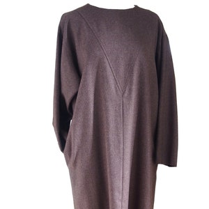 Könnte beinhalten: Ein langärmeliges braunes Kleid mit V-Ausschnitt und geradem Saum.